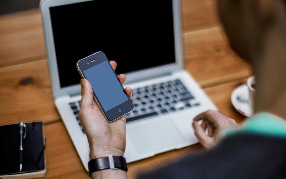 A phone propped up beside a notebook